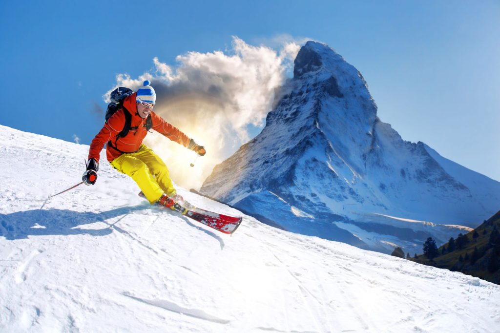 Switzerland 2 Skier going downhill, with Matterhorn in the background.